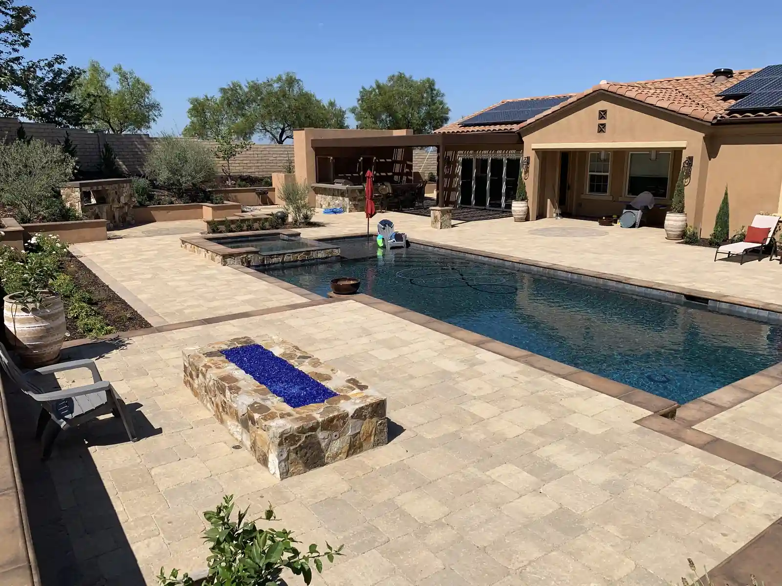 Completed outdoor living build with paver patio, pool, and fire pit in Scripps Ranch by Panjia Outdoors